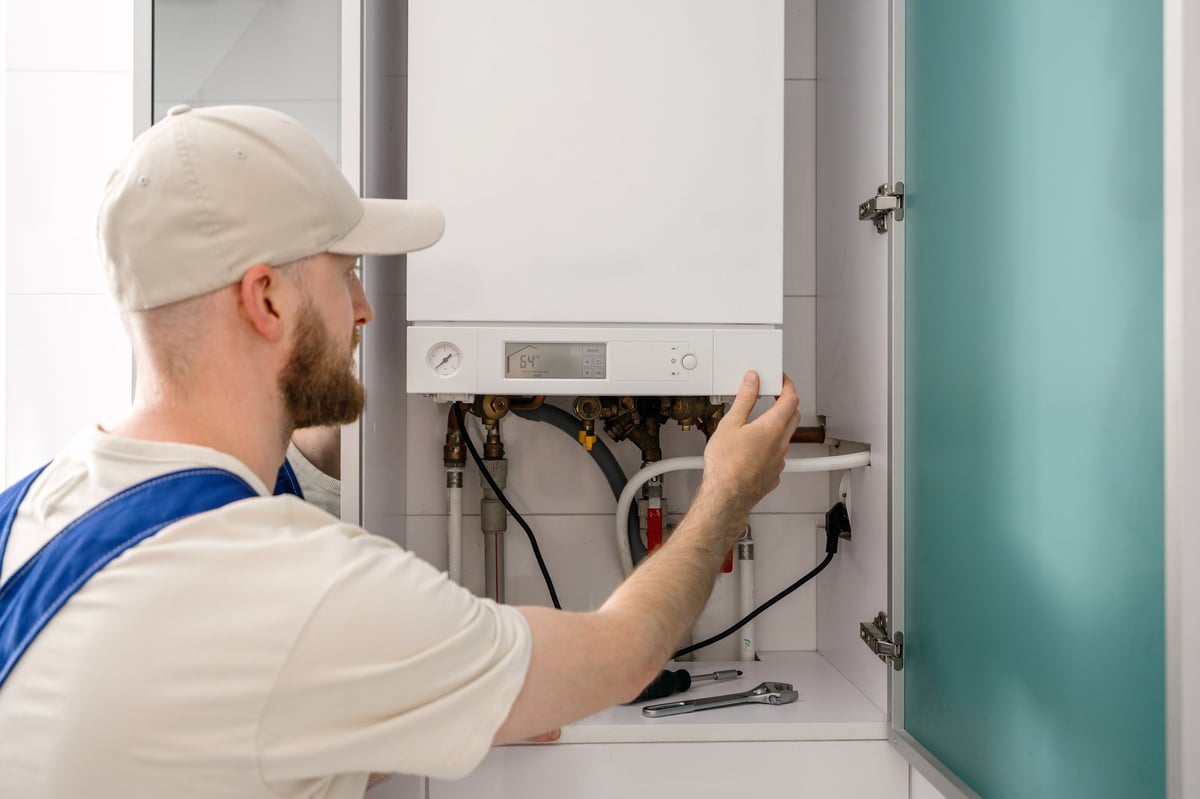 Repairman inspecting a gas boiler in a bathroom